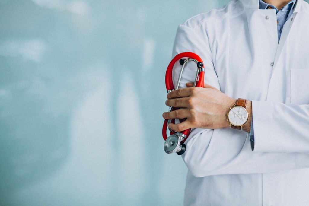 Young handsome physician in a medical robe with stethoscope